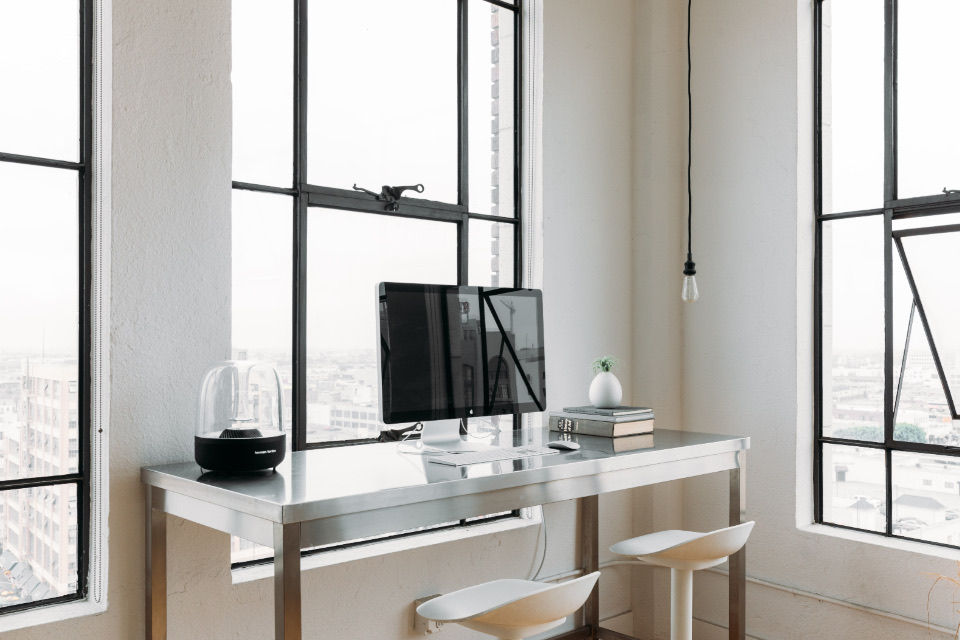 White workspace beside tall windows